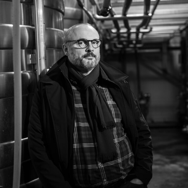 Lionel Gosseaume, vigneron producteur posant dans la cave, représentant l'expertise et la passion derrière la production de vin
